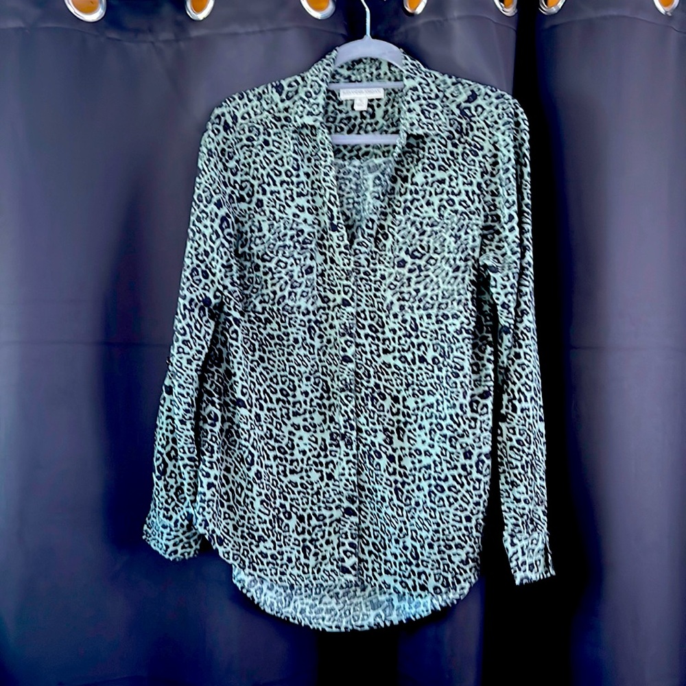 Woman’s button down leopard print shirt with sleeve tab to button up sleeve.